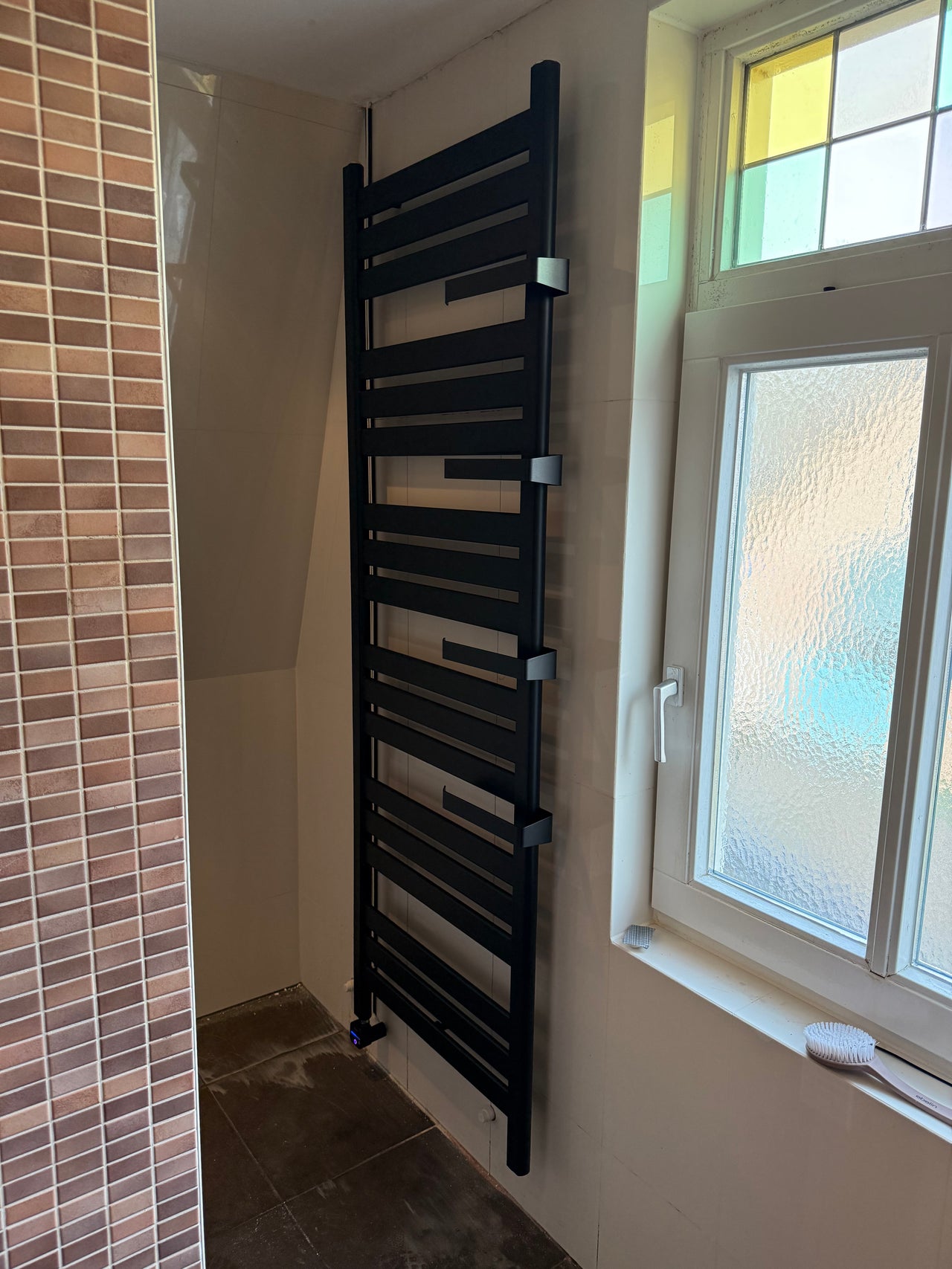 Klantfoto Heatnest Libra aluminium radiator bij klant thuis – designradiator op maat gemaakt volgens de wensen van de klant, inclusief accessoires voor handdoeken. 600х1900